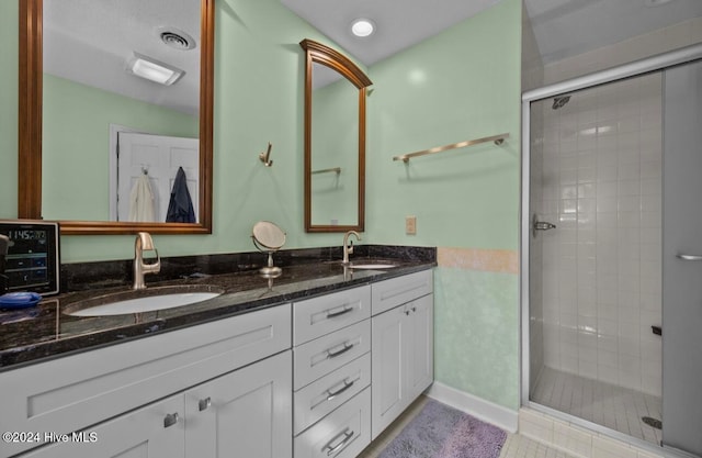 bathroom featuring vanity, tile patterned floors, and walk in shower