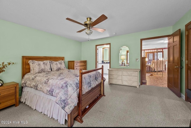 bedroom with a textured ceiling, light colored carpet, and ceiling fan