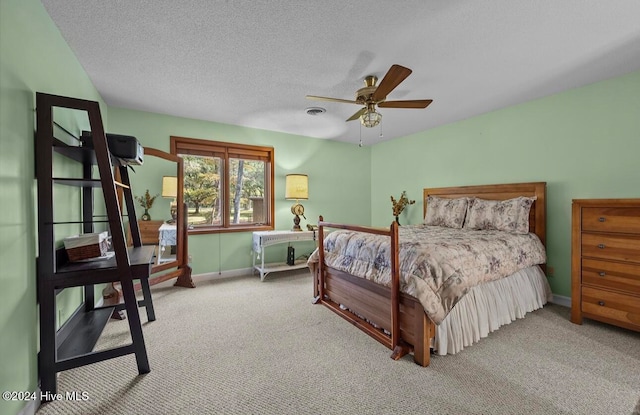 bedroom featuring ceiling fan, carpet floors, and a textured ceiling