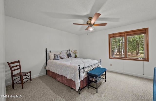 bedroom featuring ceiling fan, carpet floors, and a textured ceiling