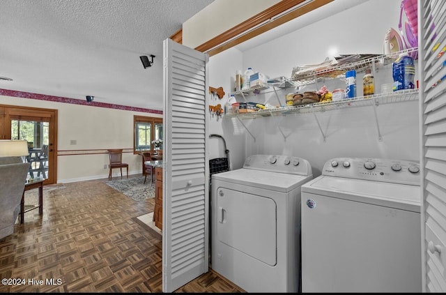 washroom with washing machine and dryer, dark parquet floors, a healthy amount of sunlight, and a textured ceiling