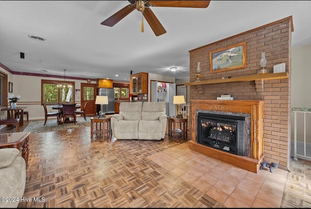 living room with a fireplace, light tile patterned floors, ceiling fan, and crown molding