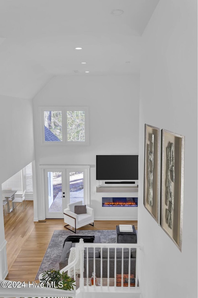 living room featuring french doors, lofted ceiling, and hardwood / wood-style flooring