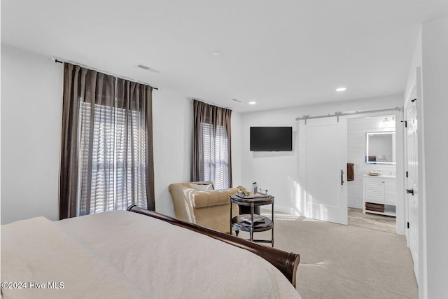 carpeted bedroom featuring a barn door