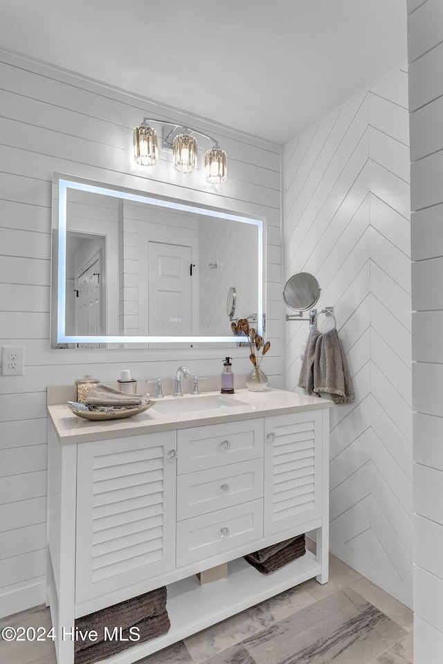 bathroom with vanity and wooden walls