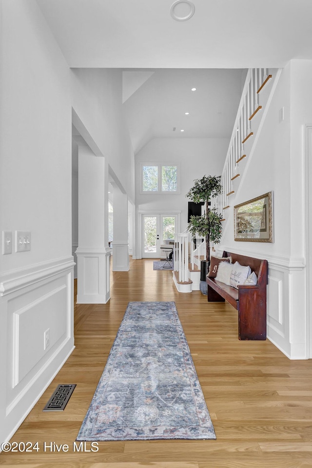 entryway featuring ornate columns, light hardwood / wood-style flooring, and french doors