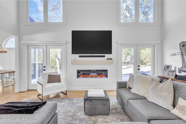 living room featuring french doors, hardwood / wood-style floors, and a high ceiling