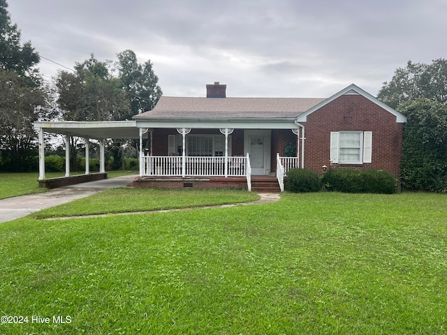 view of front of house with a front lawn, covered porch, and a carport