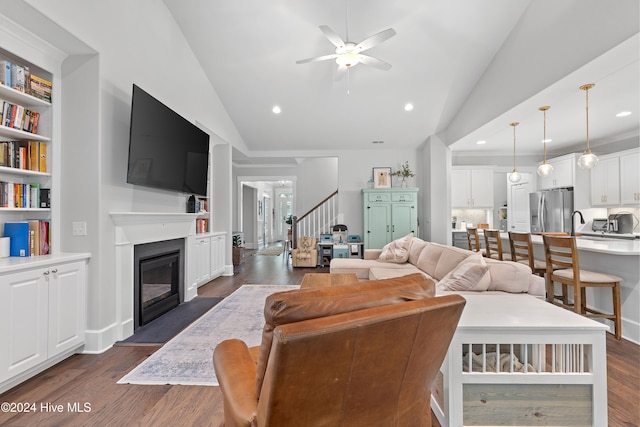 living room with ceiling fan, lofted ceiling, and dark wood-type flooring