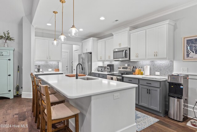 kitchen featuring white cabinets, pendant lighting, dark hardwood / wood-style flooring, and stainless steel appliances