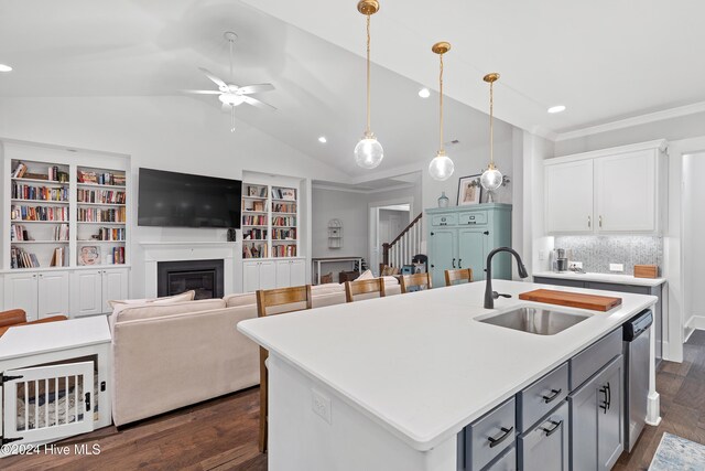 kitchen with pendant lighting, a kitchen island with sink, white cabinets, sink, and dark hardwood / wood-style floors