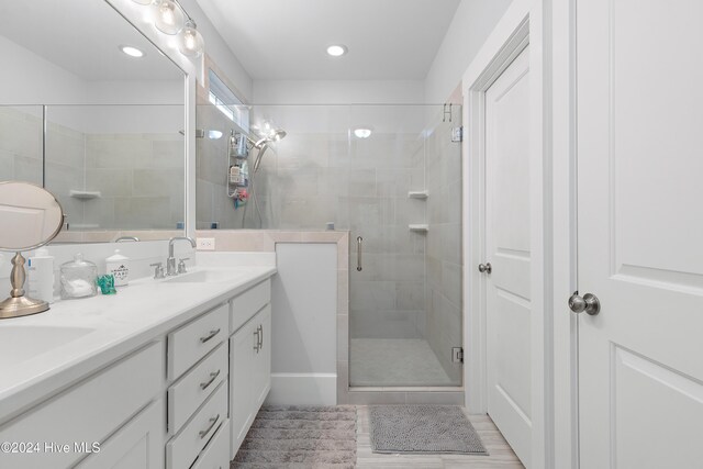 bathroom featuring vanity, wood-type flooring, and an enclosed shower