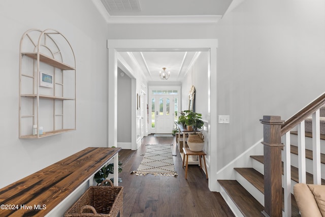 entrance foyer with dark hardwood / wood-style flooring, crown molding, and a chandelier