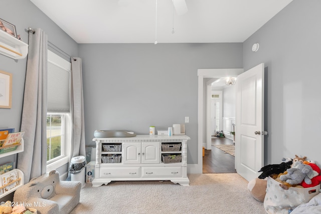 living area featuring light carpet and ceiling fan