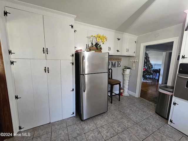 kitchen with light hardwood / wood-style floors, white cabinetry, appliances with stainless steel finishes, and crown molding