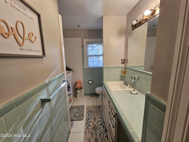 bathroom featuring vanity, tile patterned flooring, toilet, and tile walls