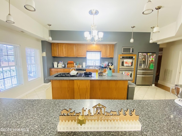 kitchen featuring pendant lighting, stainless steel appliances, light tile patterned floors, and a wealth of natural light