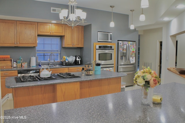 955 Mt Pisgah Rd SW, Supply, NC 28462 - kitchen with stainless steel appliances, a sink, dark countertops, a chandelier, and hanging light fixtures