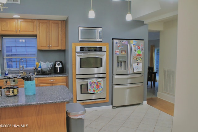 955 Mt Pisgah Rd SW, Supply, NC 28462 - kitchen featuring stainless steel appliances, light tile patterned floors, decorative light fixtures, baseboards, and a sink