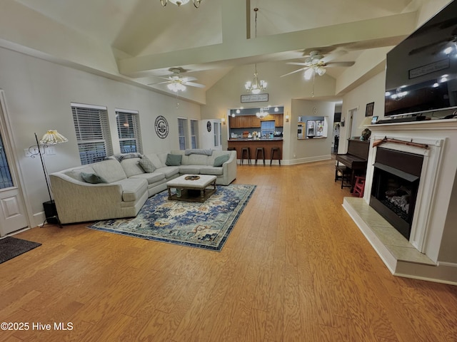 955 Mt Pisgah Rd SW, Supply, NC 28462 - living room featuring ceiling fan, high vaulted ceiling, a fireplace with raised hearth, light wood-style floors, and baseboards