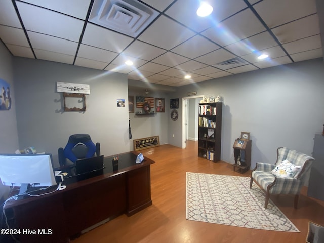 office with hardwood / wood-style floors and a paneled ceiling