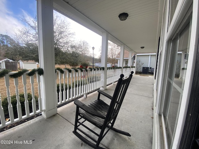 balcony with a water view and a porch