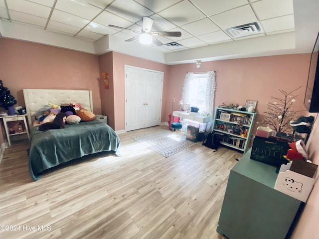 bedroom with a paneled ceiling, ceiling fan, and hardwood / wood-style floors