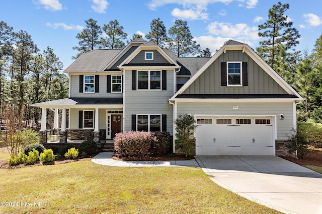 craftsman-style home with a porch, a garage, and a front yard