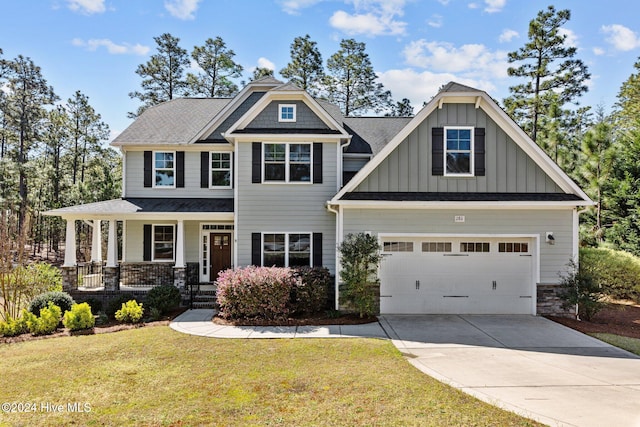 craftsman inspired home with a front yard, a garage, and covered porch