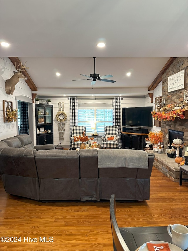 living room featuring hardwood / wood-style floors, ceiling fan, and a fireplace