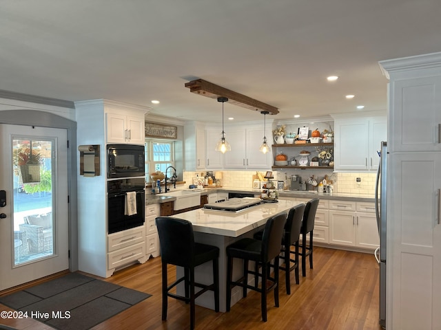kitchen featuring black appliances, white cabinetry, sink, and a healthy amount of sunlight