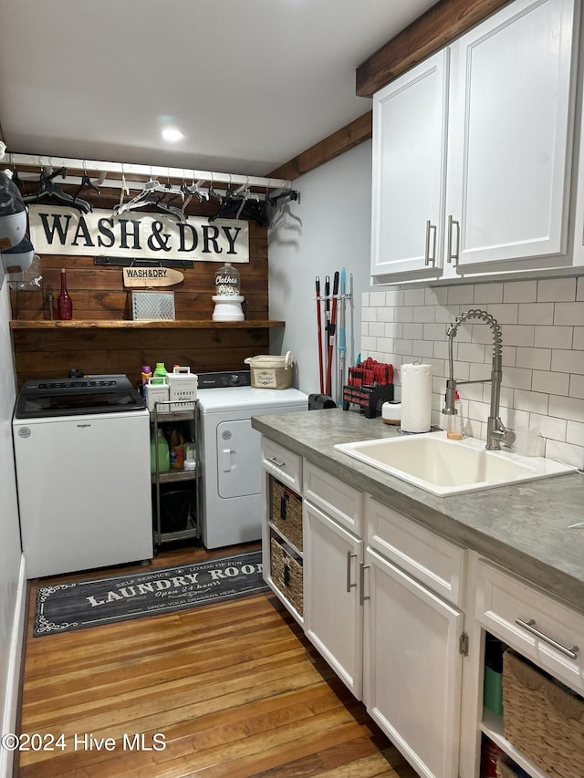 kitchen with backsplash, sink, light hardwood / wood-style flooring, washing machine and dryer, and white cabinetry