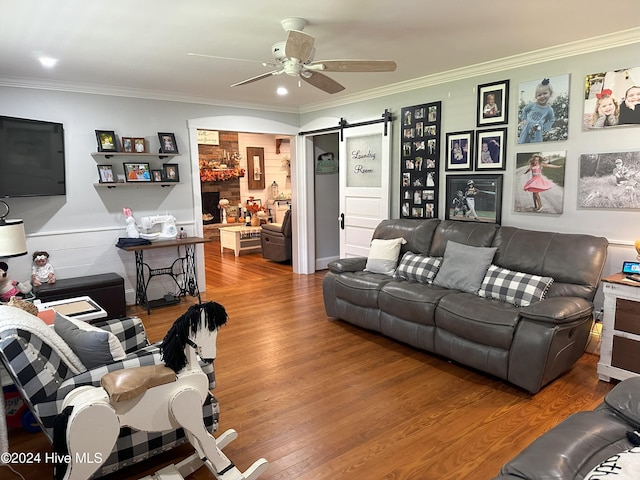 living room with hardwood / wood-style flooring, ceiling fan, and crown molding