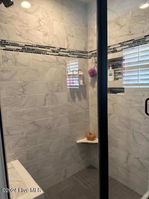 bathroom featuring a shower with door