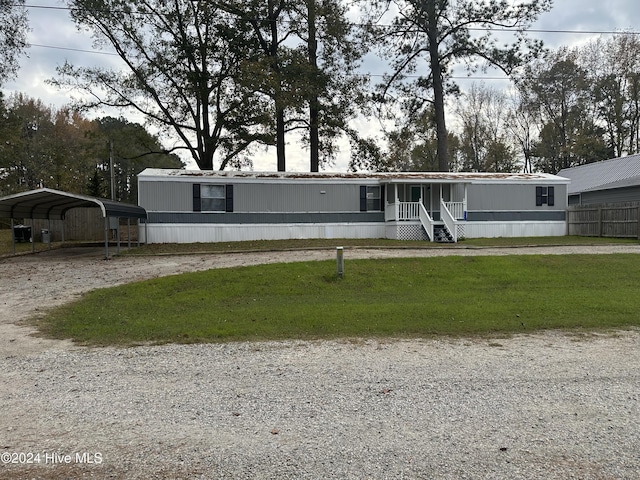 manufactured / mobile home featuring a carport and a front lawn