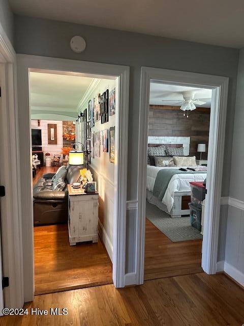hallway featuring ornamental molding and hardwood / wood-style flooring