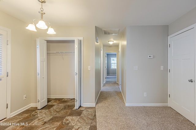 hallway featuring a chandelier and carpet floors