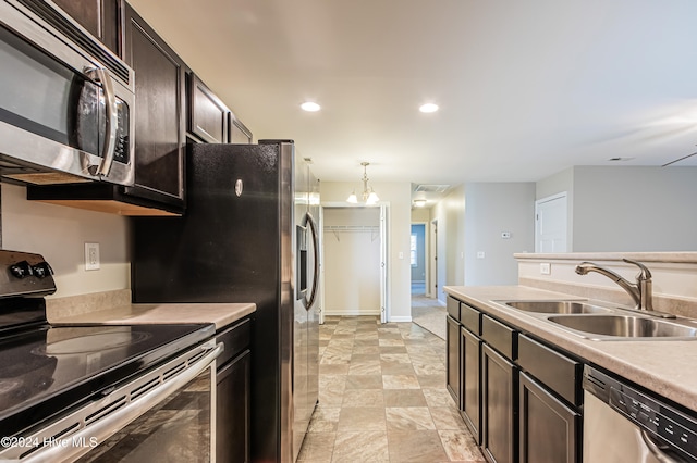 kitchen with stainless steel appliances, sink, decorative light fixtures, and dark brown cabinetry