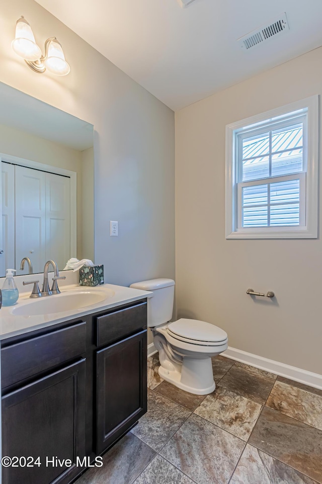 105 James Ave Unit A, Surf City, NC 28445 - bathroom featuring baseboards, vanity, toilet, and stone finish flooring