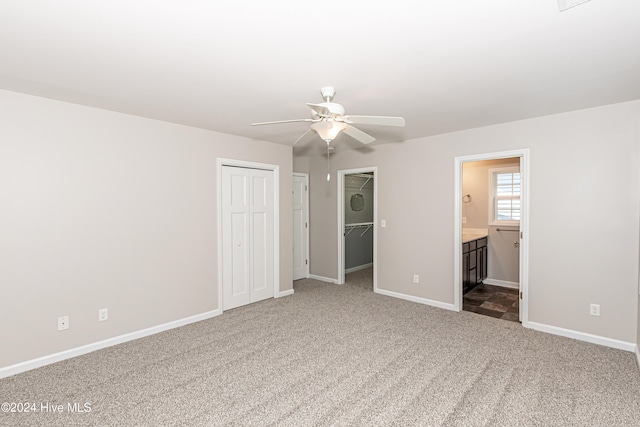 unfurnished bedroom with ceiling fan, connected bathroom, and carpet floors