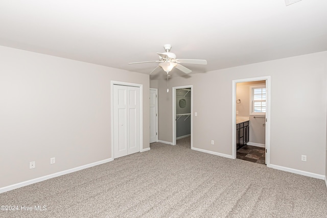 105 James Ave Unit A, Surf City, NC 28445 - unfurnished bedroom featuring carpet floors, baseboards, ensuite bathroom, ceiling fan, and two closets