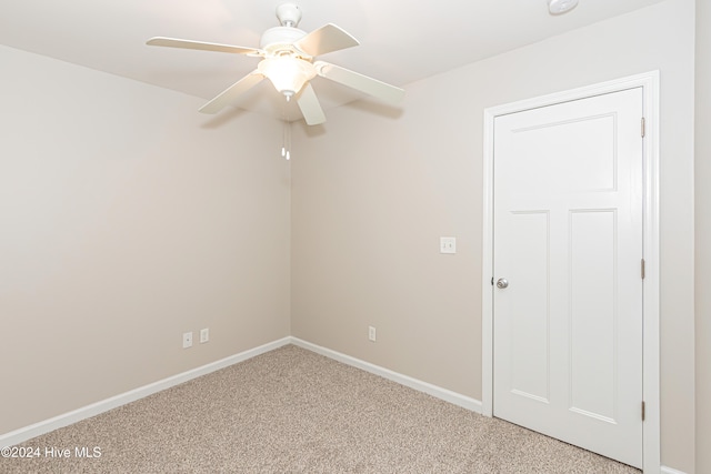 carpeted spare room with ceiling fan