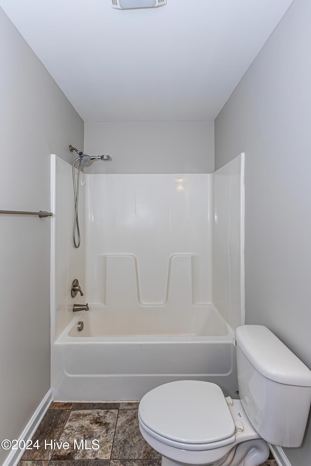 bathroom featuring shower / tub combination and toilet