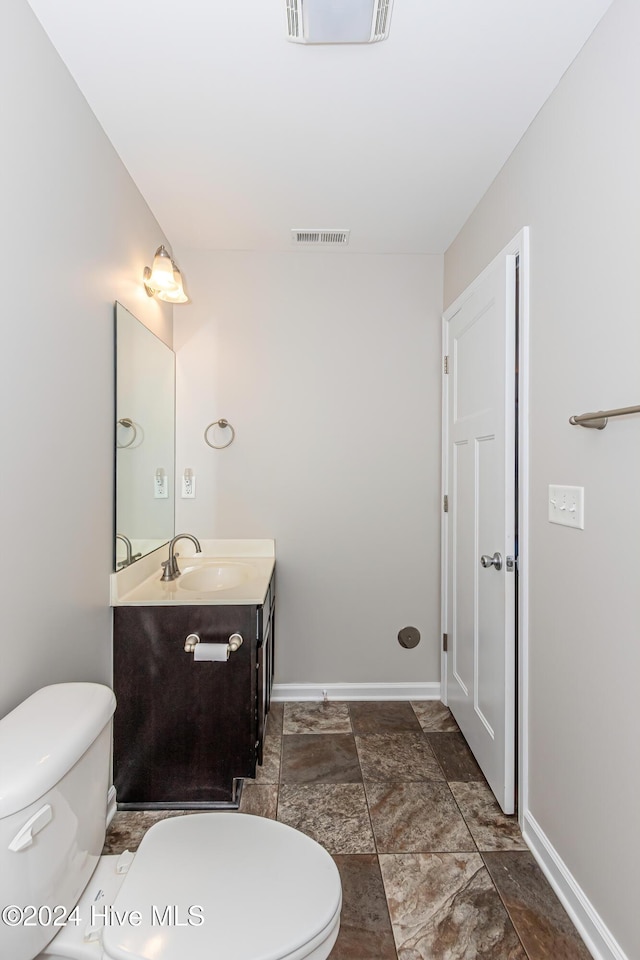 105 James Ave Unit A, Surf City, NC 28445 - bathroom featuring vanity, toilet, baseboards, and stone finish floors