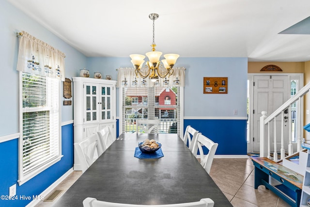 tiled dining room with a notable chandelier