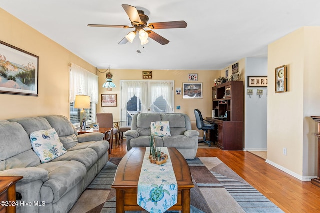 living room with hardwood / wood-style floors, ceiling fan, and french doors