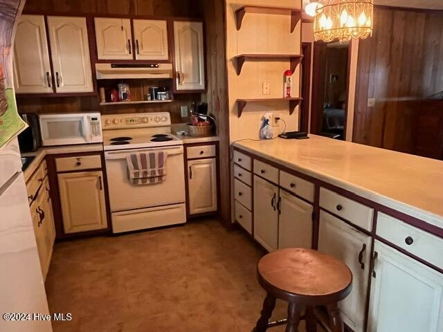 kitchen featuring white appliances, a notable chandelier, and hanging light fixtures