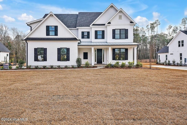 modern farmhouse style home featuring a porch and a front lawn