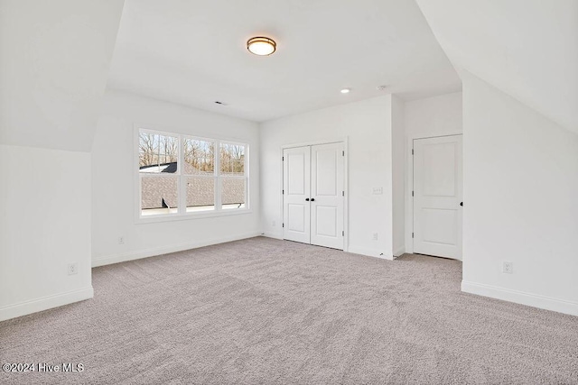 additional living space featuring carpet flooring and vaulted ceiling