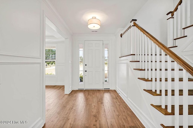 entrance foyer with hardwood / wood-style flooring and crown molding